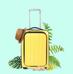 Image of Yellow travel suitcase, hat, seashells, tropical leaves and flowers on light blue background