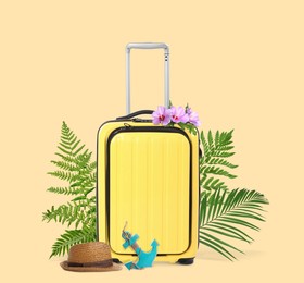 Image of Yellow travel suitcase, hat, toy anchor, tropical leaves and flowers on beige background