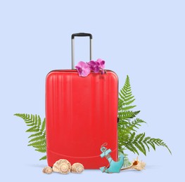 Image of Red travel suitcase, seashells, toy anchor, tropical leaves and flowers on light violet blue background