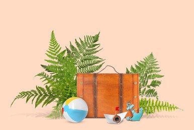 Image of Brown travel suitcase, tropical leaves, beach ball, toy anchor and paper boat on pink beige background