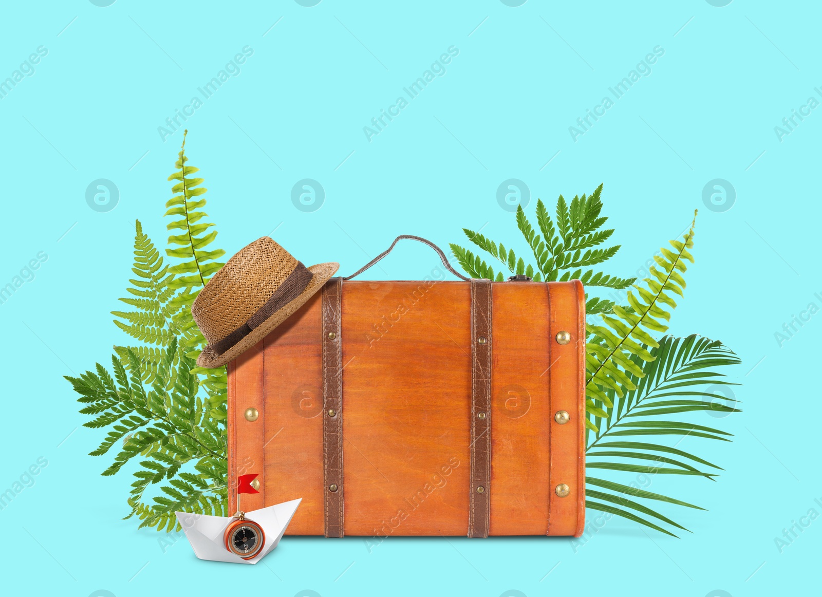 Image of Brown travel suitcase, tropical leaves, hat and paper boat on cyan color background