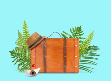 Image of Brown travel suitcase, tropical leaves, hat and paper boat on cyan color background