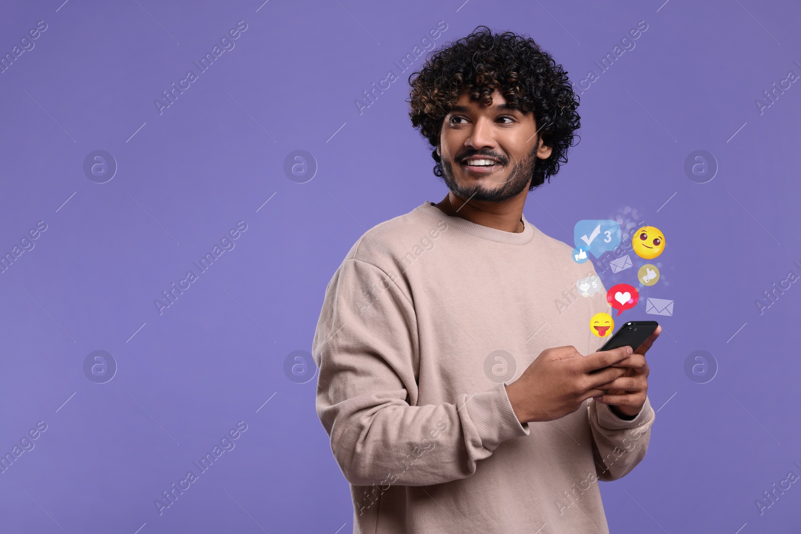 Image of Happy man using mobile phone on violet background. New message sign and other notifications over gadget