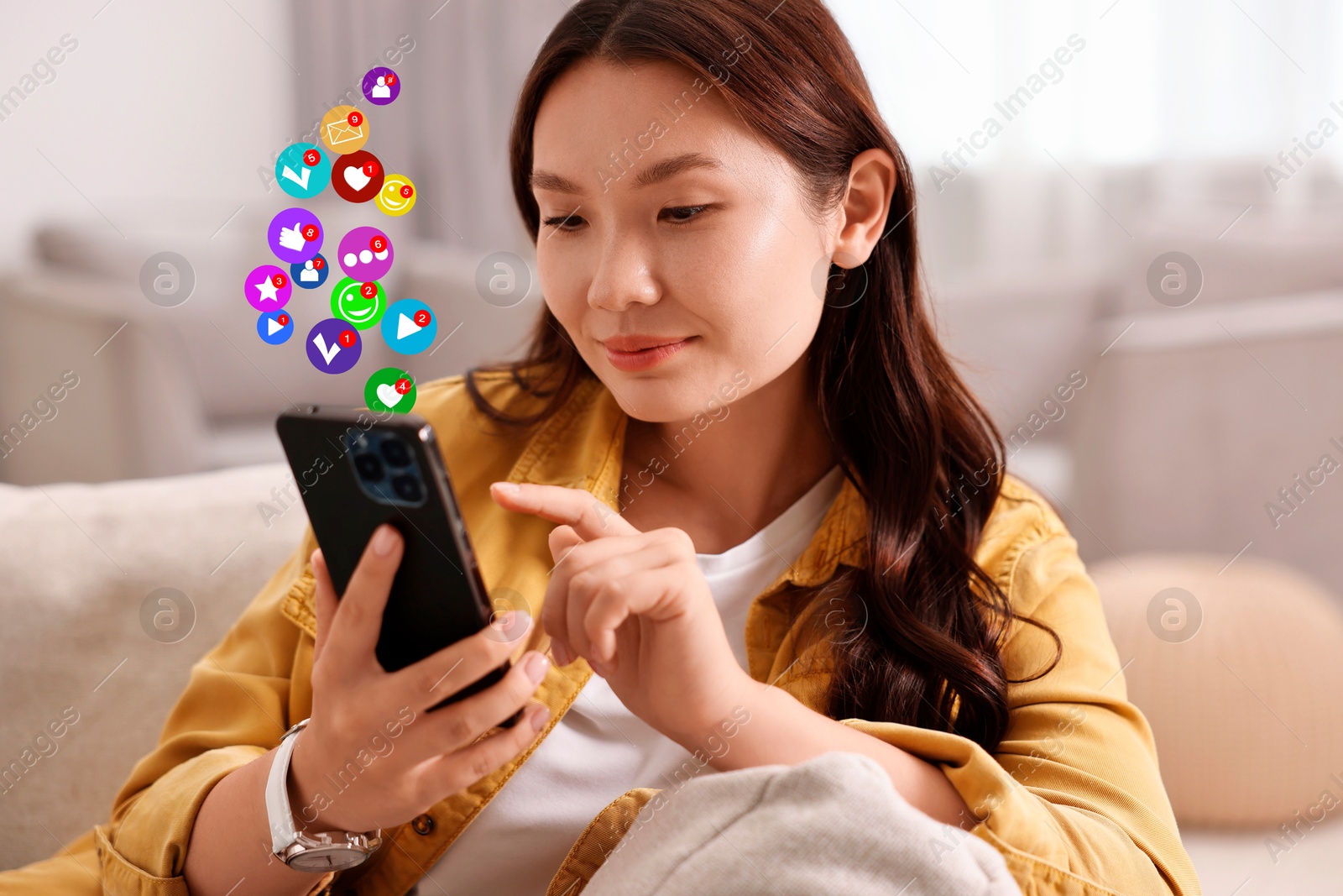 Image of Happy woman using mobile phone at home. New message sign and other notifications over gadget