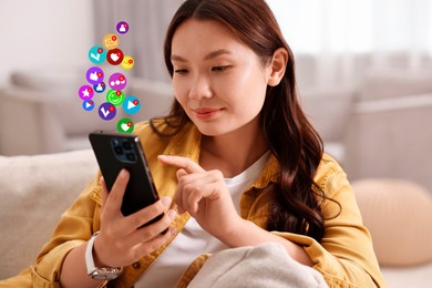 Image of Happy woman using mobile phone at home. New message sign and other notifications over gadget