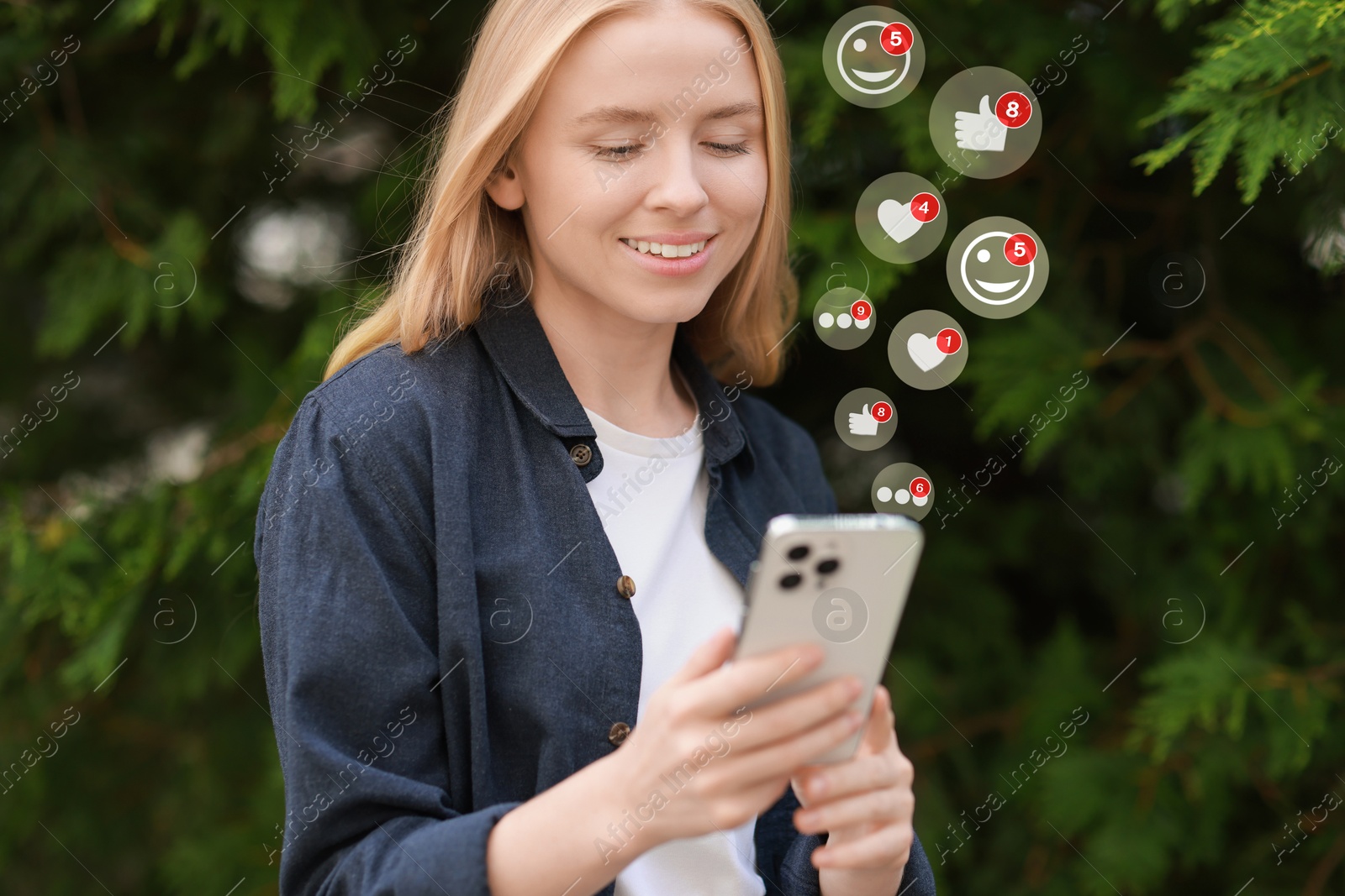 Image of Happy woman using mobile phone outdoors. Different notification signs over gadget