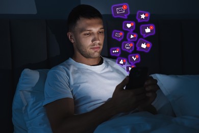 Image of Man using mobile phone in bed at night. New message sign and other notifications over gadget