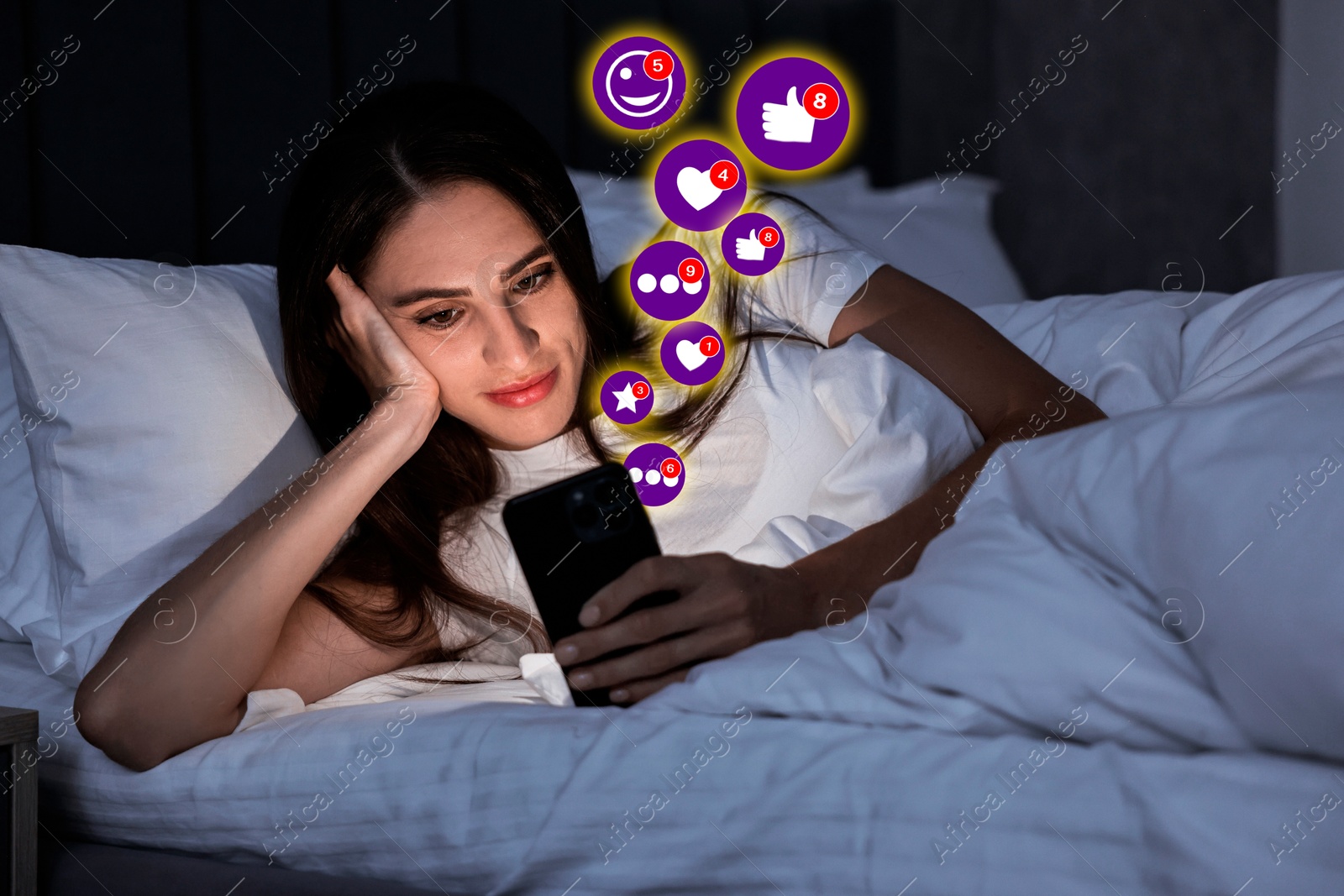 Image of Woman using mobile phone in bed at night. Different notification signs over gadget