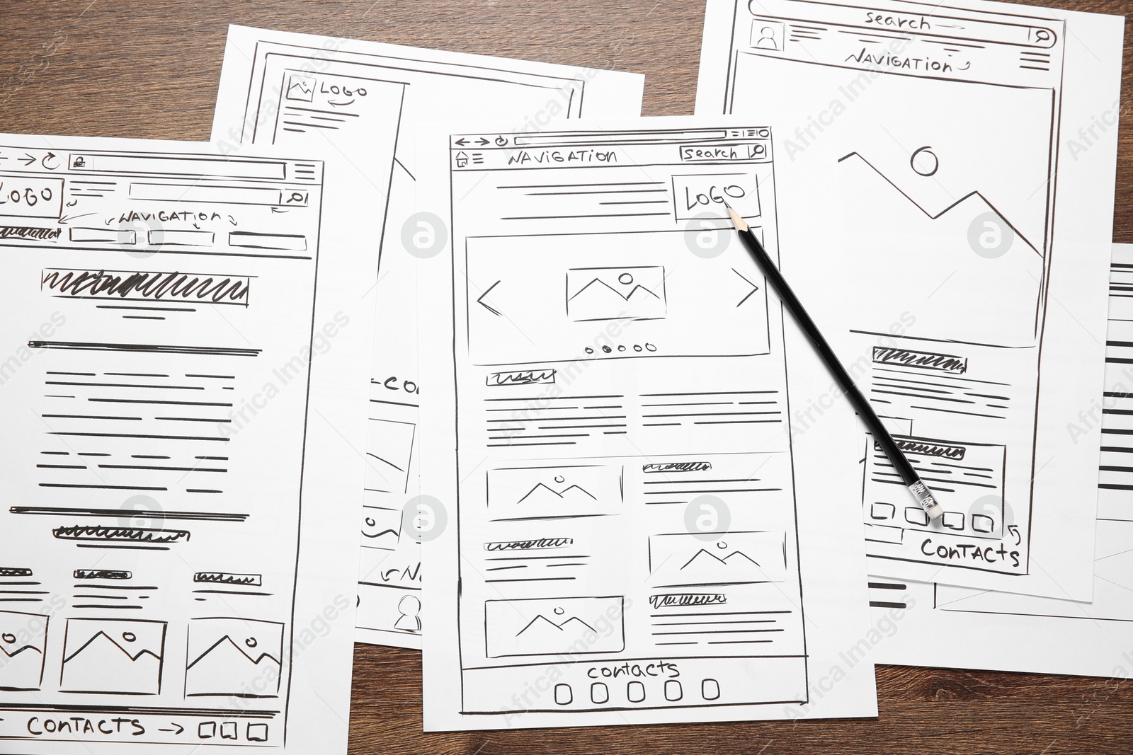 Photo of Developing UI design. Sketches of website wireframes and pencil on wooden table, top view