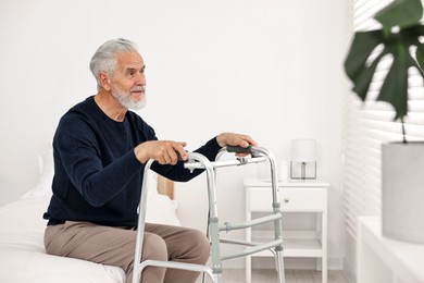 Senior man with walking frame on bed in hospital ward