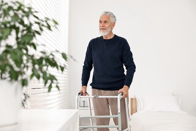 Senior man with walking frame in hospital ward