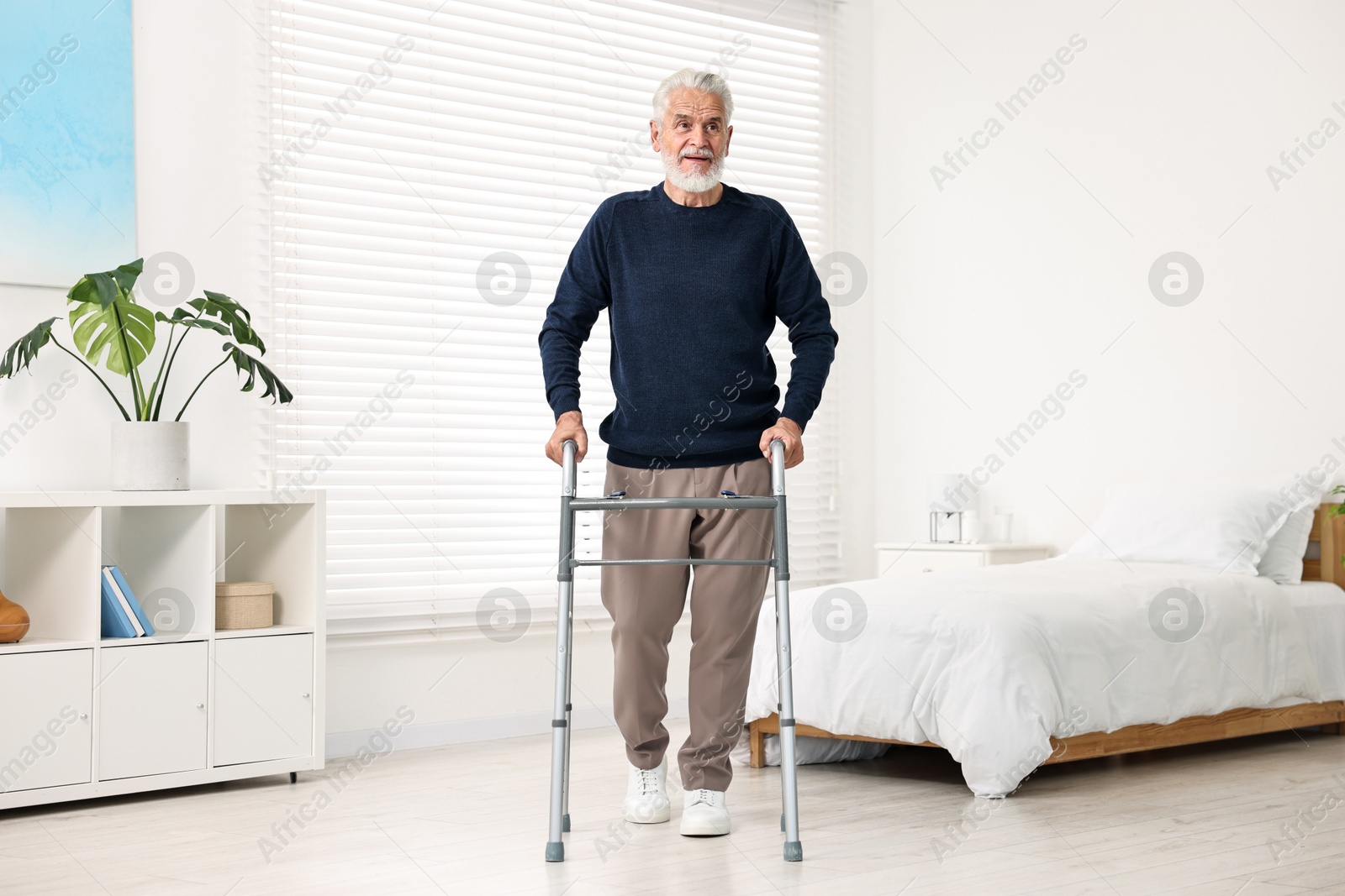 Photo of Senior man with walking frame in hospital ward