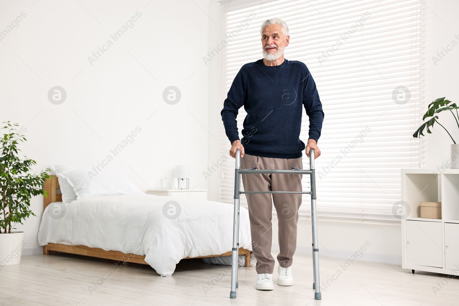 Photo of Senior man with walking frame in hospital ward