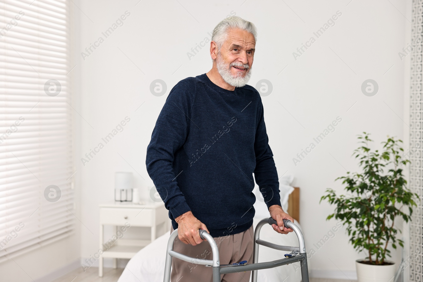 Photo of Senior man with walking frame in hospital ward