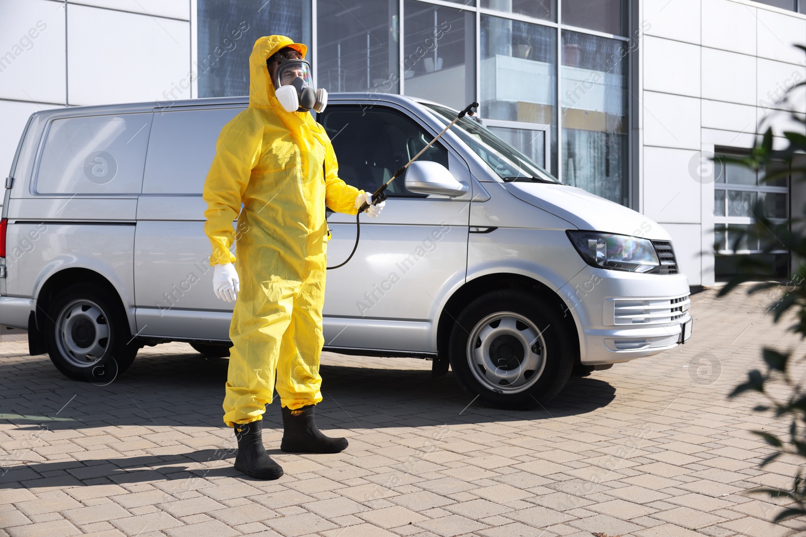 Photo of Pest control worker with spray tank outdoors