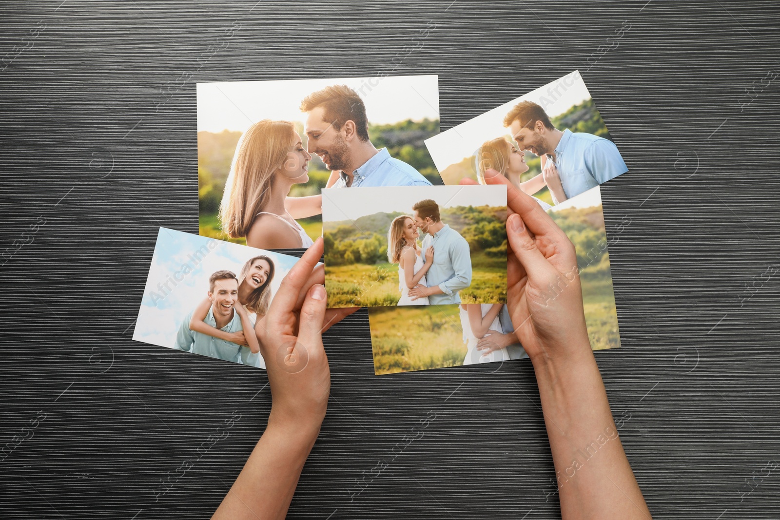 Photo of Woman with different photos at black wooden table, top view