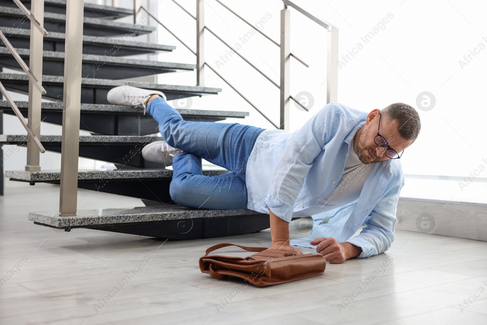 Photo of Injured man on stairs in building after fall. Dangerous accident