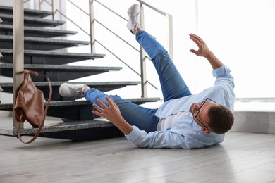 Photo of Injured man on floor in building after fall from stairs. Dangerous accident