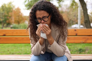 Photo of Young woman with runny nose in park