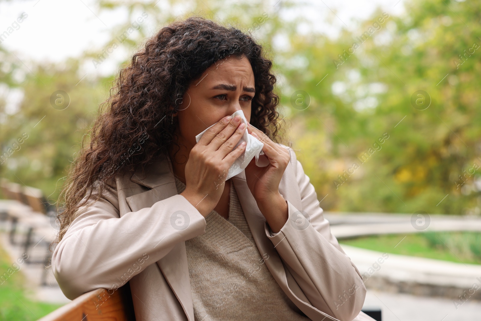 Photo of Young woman with runny nose in park