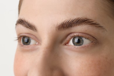 Photo of Young woman with beautiful eyes on light background, closeup