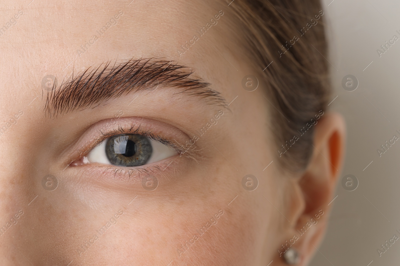 Photo of Young woman with beautiful eyes on light background, closeup