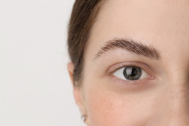 Photo of Young woman with beautiful eyes on light background, closeup