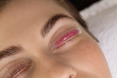 Photo of Woman undergoing eyelash laminating procedure in beauty salon, closeup