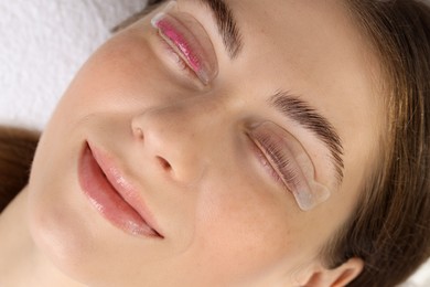 Photo of Woman undergoing eyelash laminating procedure in beauty salon, closeup