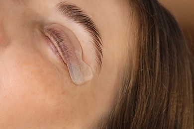 Photo of Woman undergoing eyelash laminating procedure in beauty salon, closeup