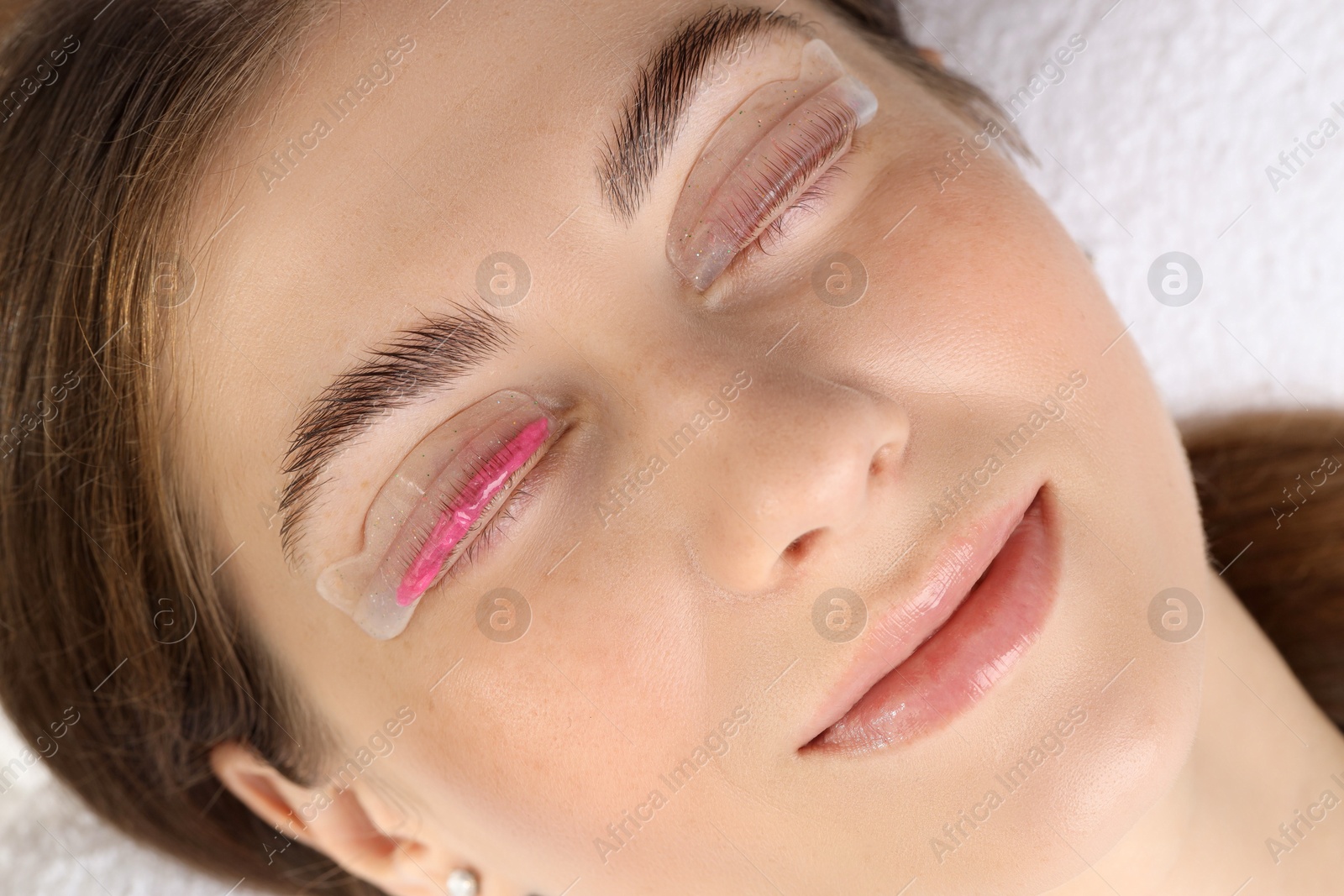 Photo of Woman undergoing eyelash laminating procedure in beauty salon, closeup