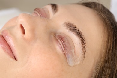 Photo of Woman undergoing eyelash laminating procedure in beauty salon, closeup