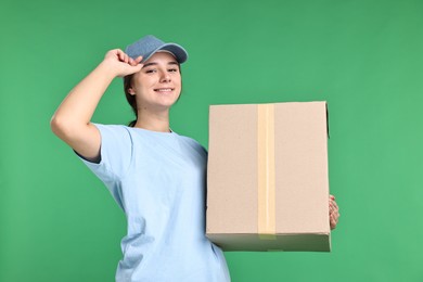 Photo of Girl in uniform with parcel on green background. Work for teenagers