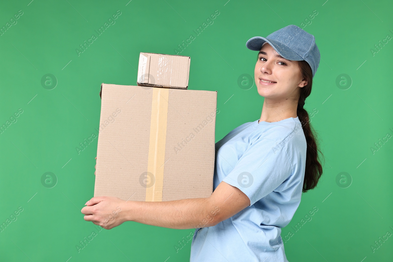 Photo of Girl in uniform with parcels on green background. Work for teenagers