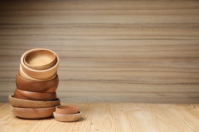 Photo of Stack of bowls on wooden table, space for text. Cooking utensils