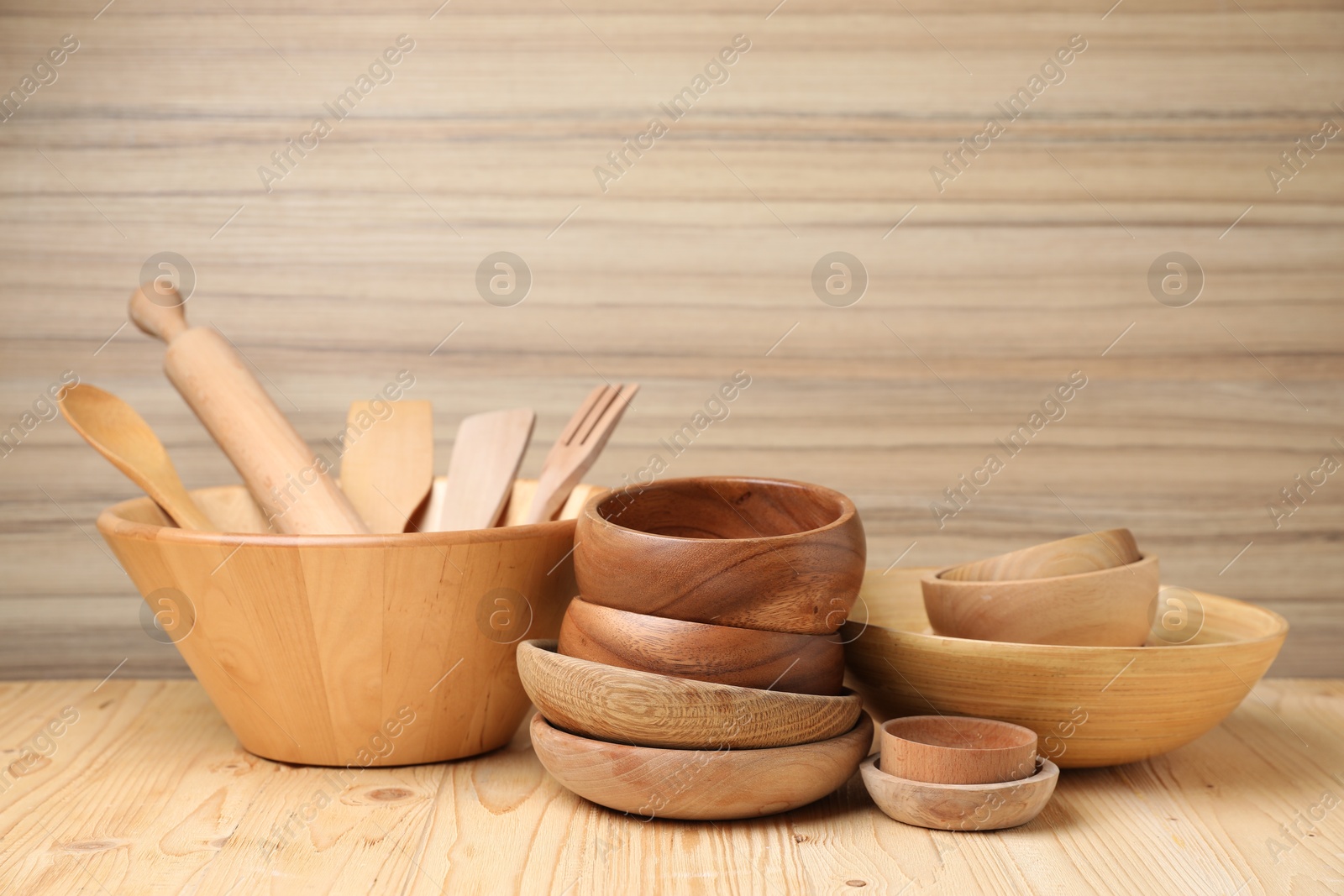 Photo of Dishware and cooking utensils on wooden table, space for text