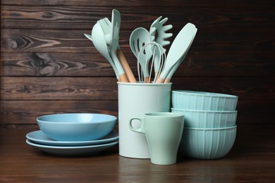 Photo of Dishware and cooking utensils on wooden table