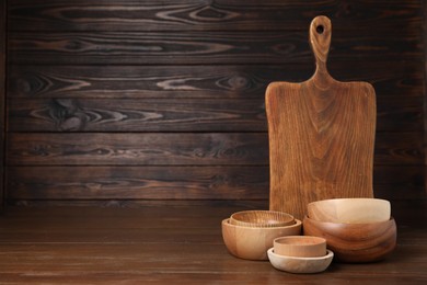 Photo of Bowls and board on wooden table, space for text. Cooking utensils