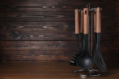 Photo of Set of cooking utensils on wooden table, space for text