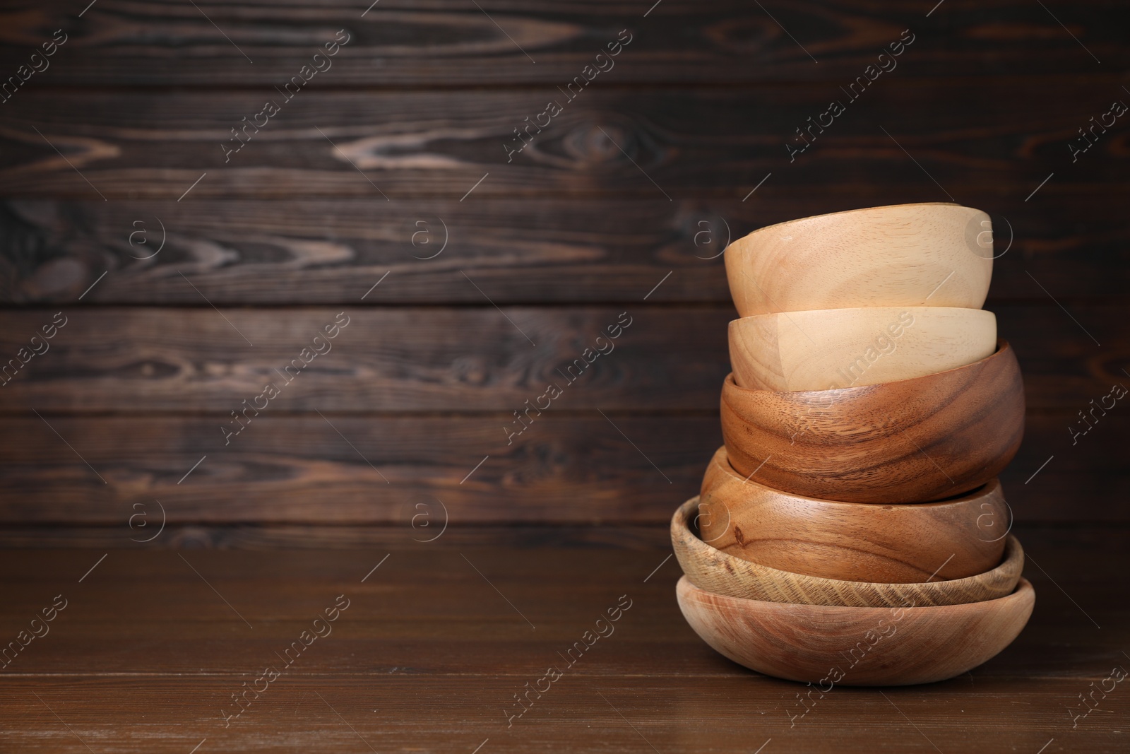 Photo of Stack of bowls on wooden table, space for text. Cooking utensils