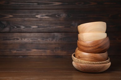 Photo of Stack of bowls on wooden table, space for text. Cooking utensils