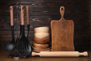 Photo of Dishware and cooking utensils on wooden table