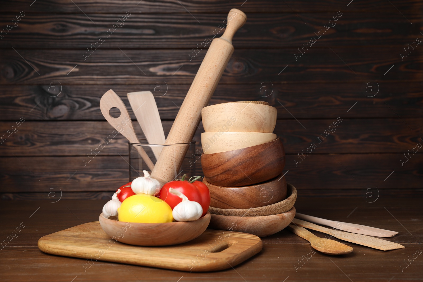 Photo of Dishware, cooking utensils with vegetables and lemon on wooden table