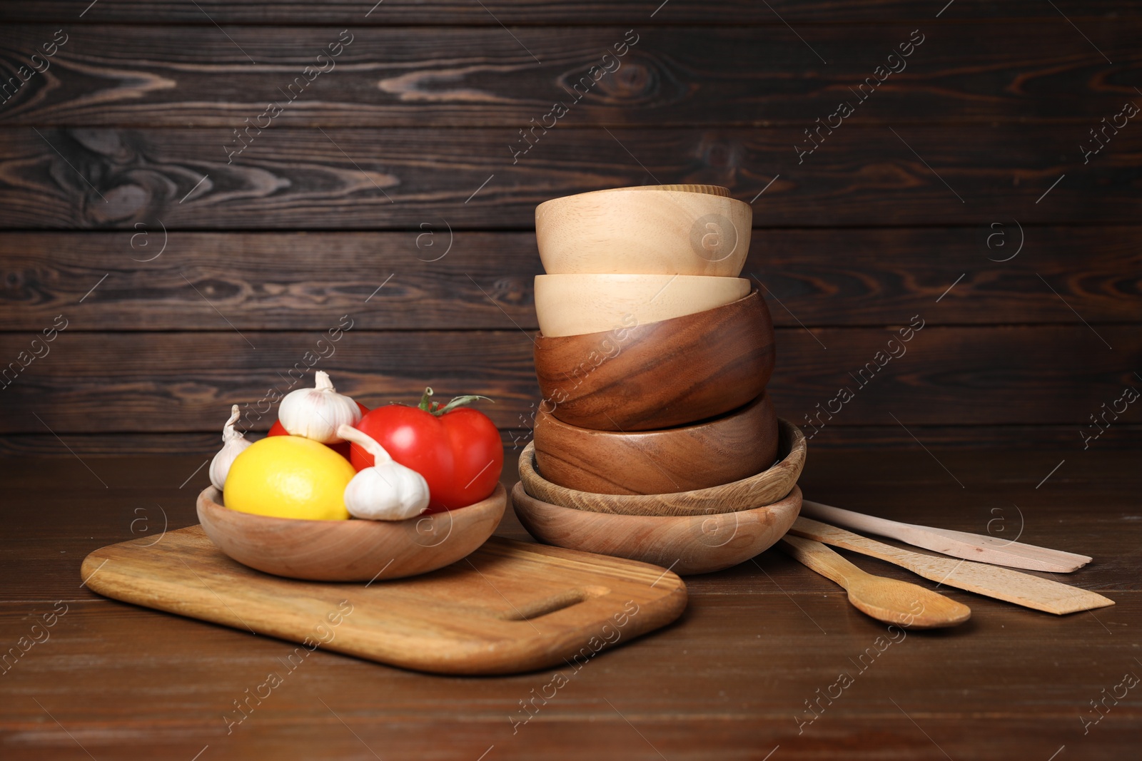 Photo of Dishware, cooking utensils with vegetables and lemon on wooden table