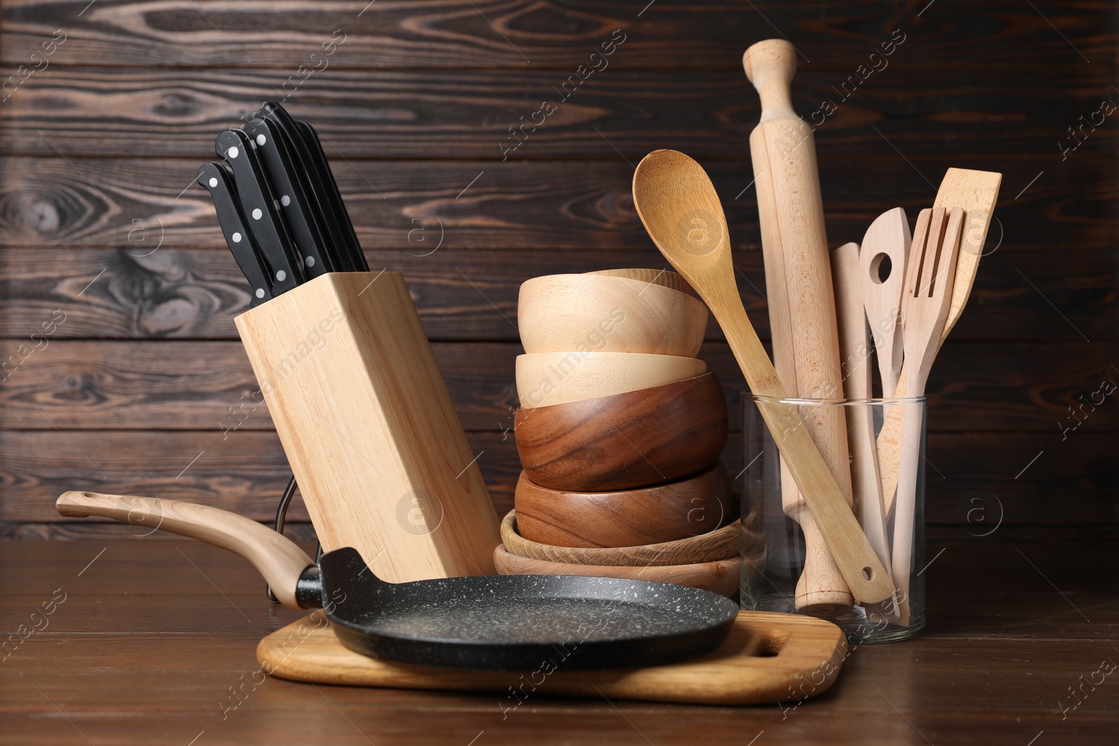 Photo of Dishware and cooking utensils on wooden table