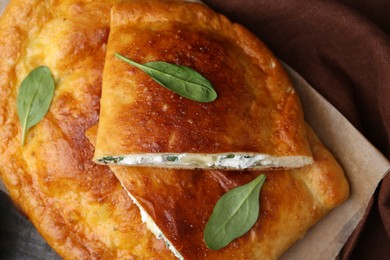 Photo of Tasty calzones with cheese and basil on table, above view