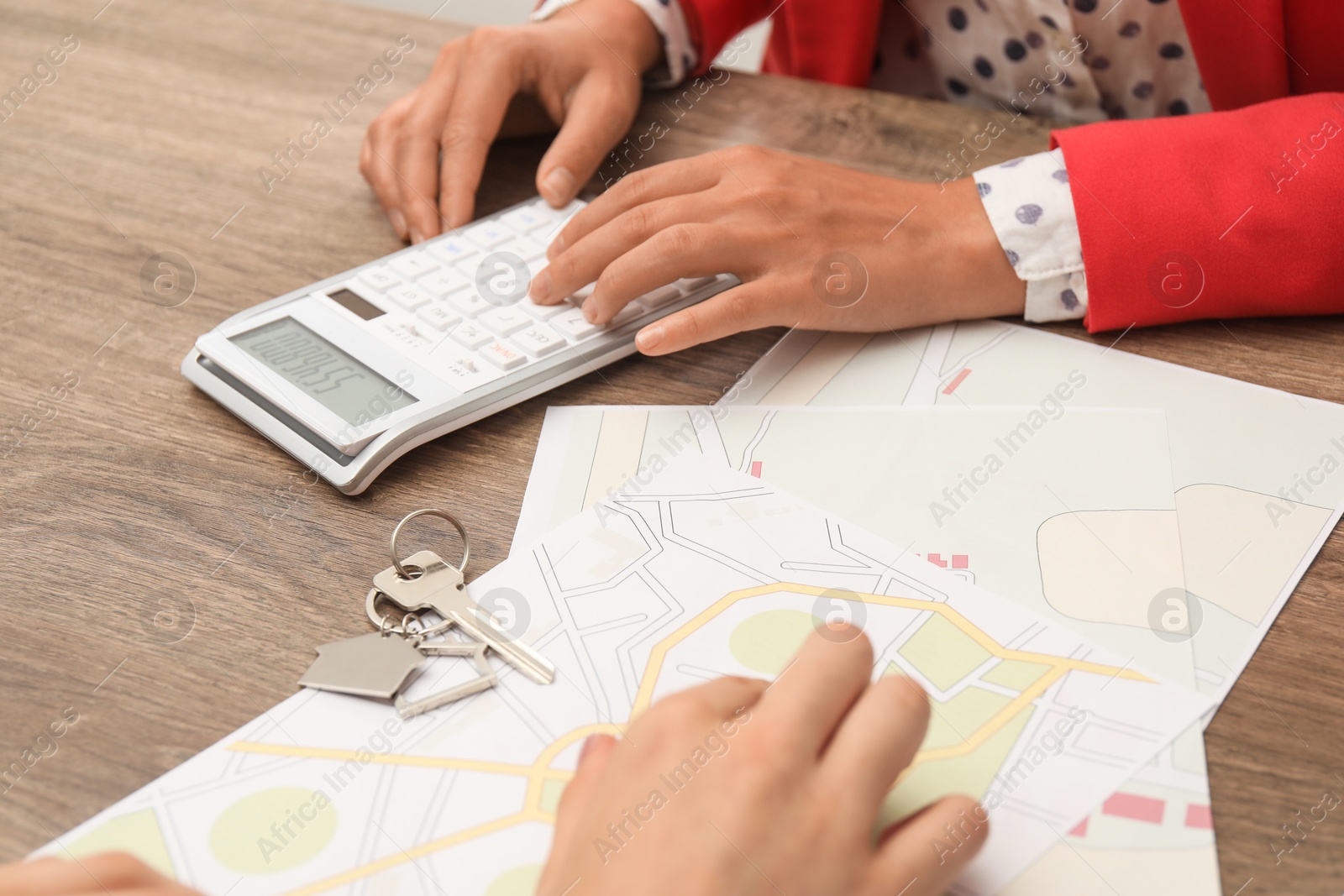 Photo of Real estate agent working with client at wooden table, closeup