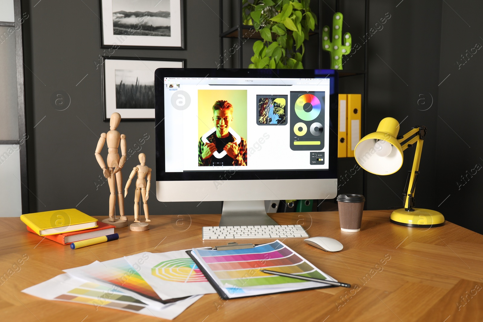 Photo of Designer's workplace with computer, stationery and palettes on wooden table indoors