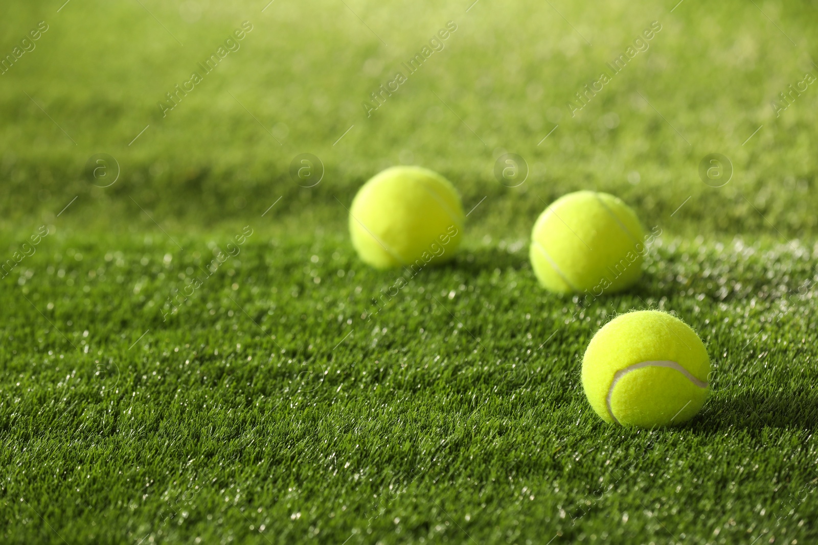 Photo of Tennis balls on green artificial grass, space for text