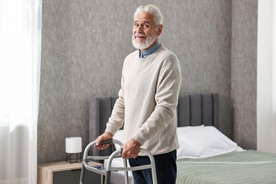 Photo of Senior man using walking frame at home